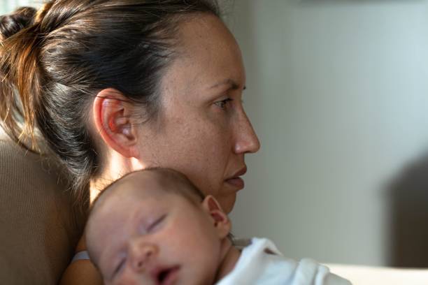 Young-mother-perhaps-with-postpartum-depression-holding-baby.