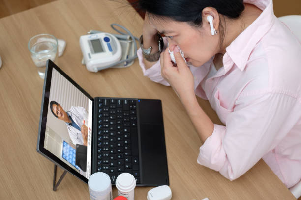 asian woman telemedicine doctor online visit with computer at home